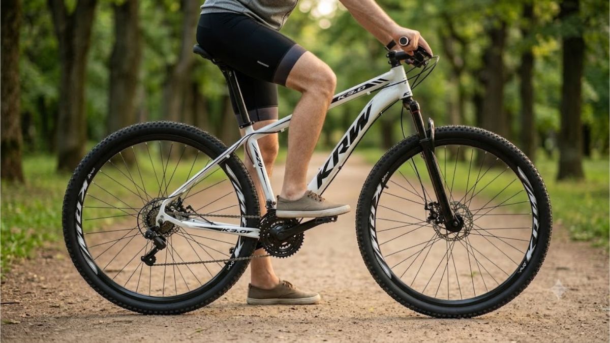 Bicicleta KRW R1 Aro 29 24V em destaque durante passeio por uma estrada de terra cercada por vegetação.