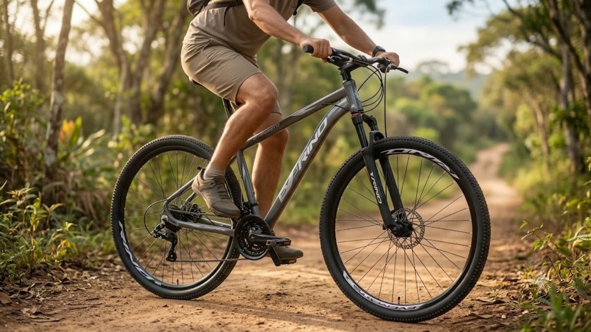 Bicicleta Rino Everest Aro 29 24V em destaque durante passeio por uma estrada de terra cercada por vegetação.